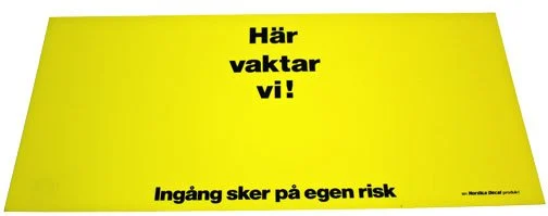 Dekalskylt Här Vaktar Vi! Gul